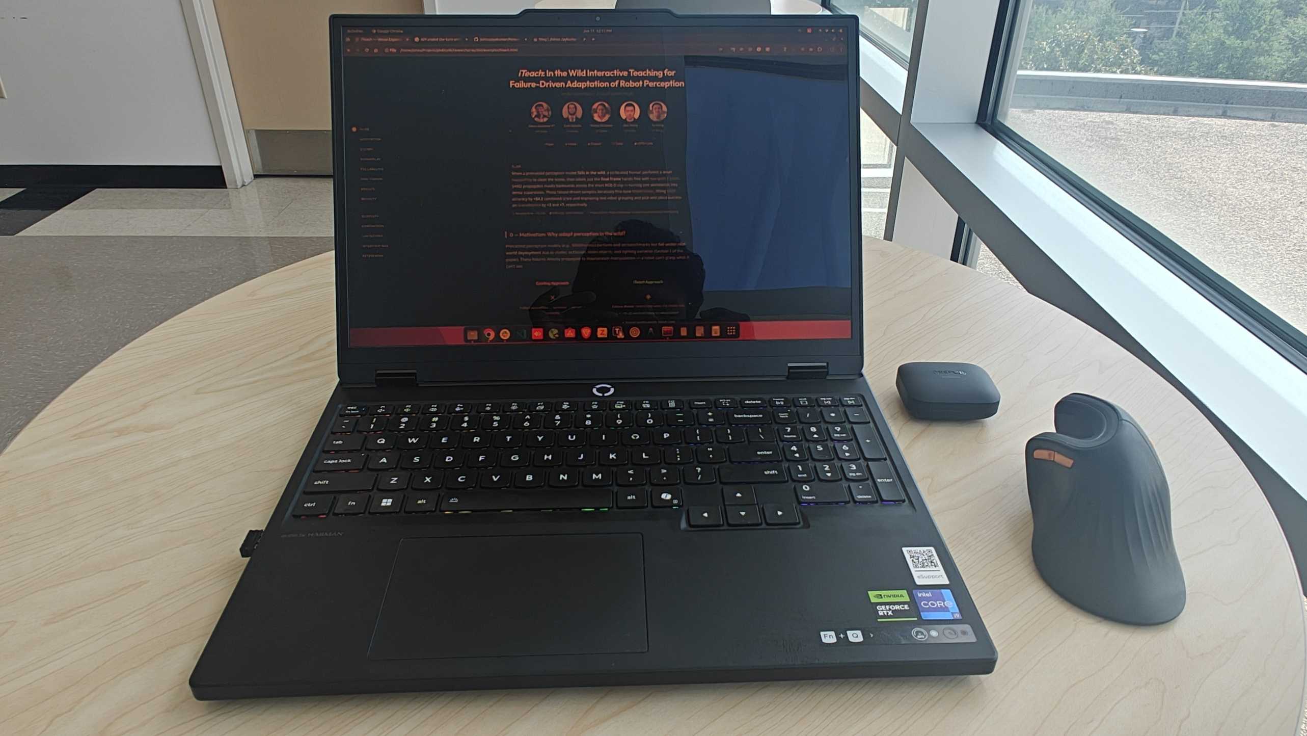 Lenovo Legion laptop on a table by the window, outside the lab